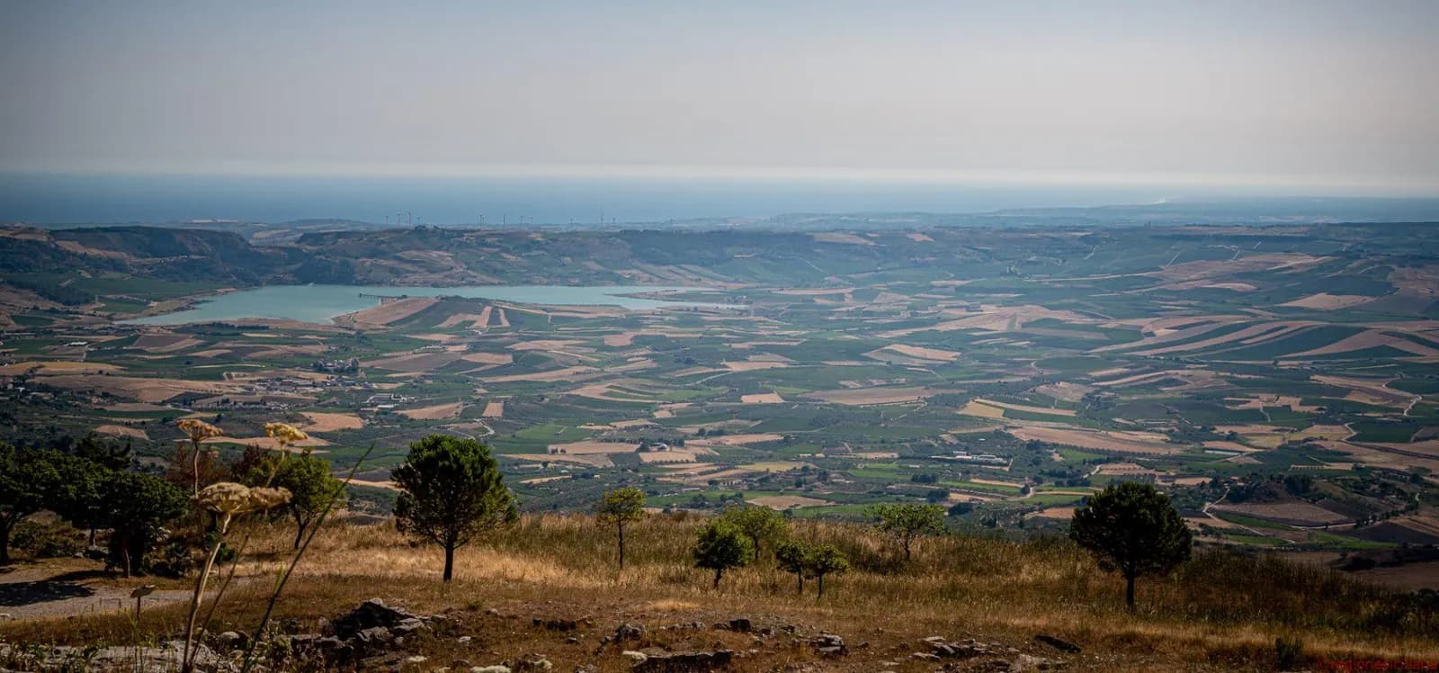 Panorama della campagna intorno a Sambuca, con un lago e il mare sullo sfondo